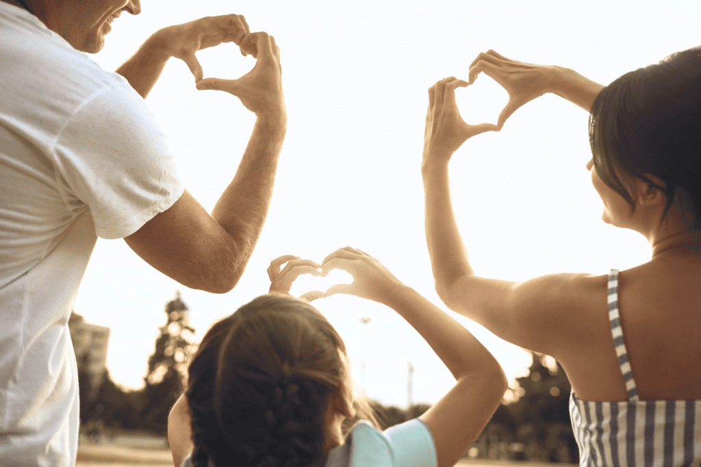 Family making hearts with hands after finding insurance resources from The World Changers